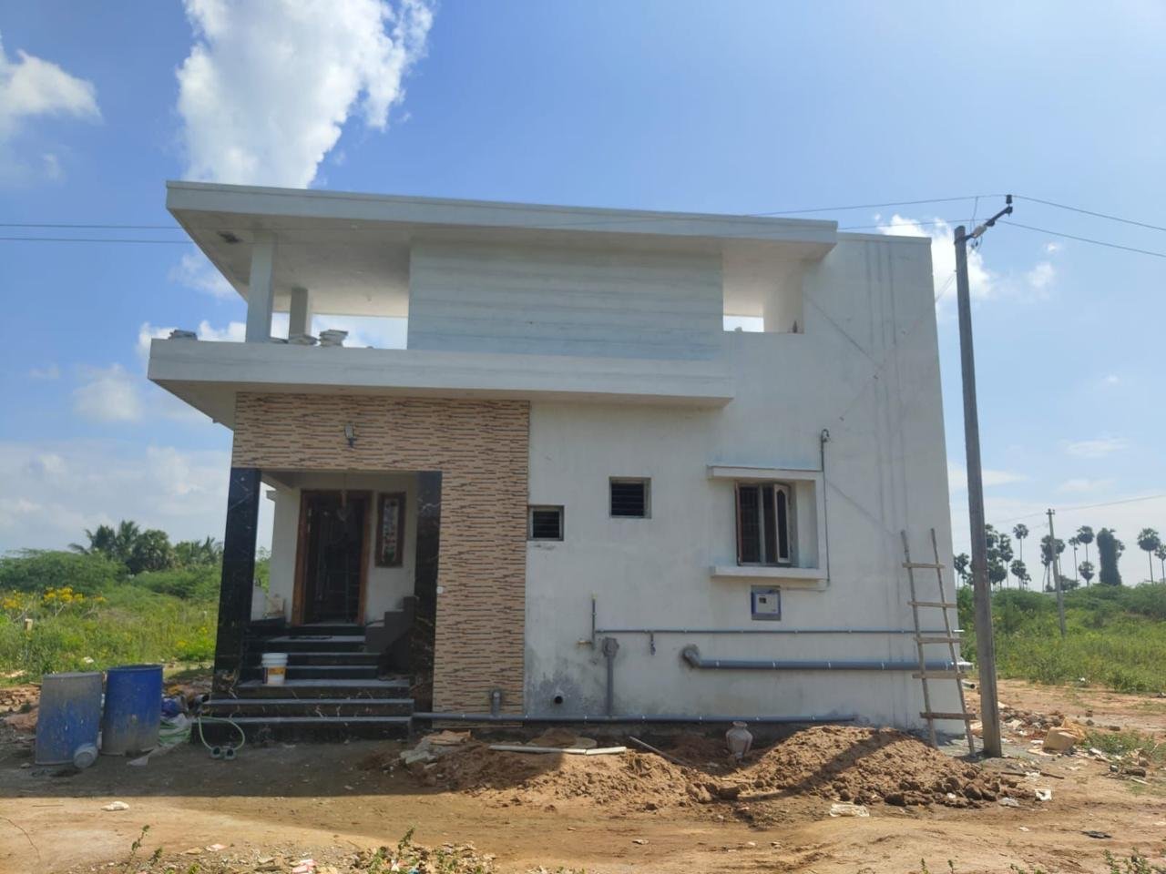1000 sq.ft residential home with stone cladding elevation in Melur